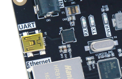 图片显示了一个USB转串口电路板的局部,电路板上标有“UART”和“Ethernet”字样。电路板上有一个USB接口和两个LED指示灯,分别标有“TX”和“RX”,用于指示串口数据的发送和接收状态。图片中的USB接口和LED指示灯是USB转串口电路设计示意图的实物图,用于直观展示USB转串口的实际连接和信号指示情况。