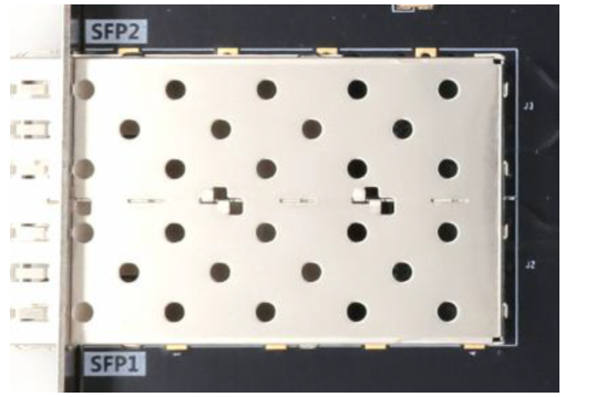 图片显示了扩展板上的两路光纤接口实物图，其中SFP1和SFP2标识清晰可见。接口部分由多个圆形孔洞组成，每个孔洞周围有金属片，用于固定光纤模块。图片在上下文中起到直观展示光纤接口实物的作用，帮助读者更好地理解光纤接口在扩展板上的布局和实际安装情况。