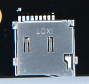 图片中展示了一个SD卡槽的实物图,卡槽上标有“LOXI”字样,卡槽的两侧有明显的凹槽和凸起,用于卡住SD卡。图片在上下文中起到直观展示SD卡槽外观的作用,帮助读者更好地理解SD卡槽的结构和安装方式。