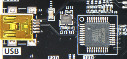 图片显示了AX7035开发板上的USB2.0接口实物图，包括USB连接器和FT232H芯片。USB连接器位于左侧，带有“USB”标识，右侧是FT232H芯片，其管脚标识为RXD和TXD。图片在文档中用于展示USB2.0接口在扩展板上的实际连接情况，帮助读者理解USB芯片与FPGA的接口关系。