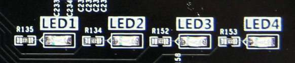 图片内容：图片展示了扩展板上的四个LED灯（LED1至LED4）及其对应的电阻（R135至R153）。每个LED灯旁边都有一个箭头指向，表明它们的连接方向。图片中还标注了LED灯的序号，便于识别。 图片作用：这张图片是文档中关于LED灯硬件连接示意图的一部分，它直观地展示了扩展板上四个用户LED灯的实物位置和连接方式，帮助读者更好地理解LED灯的硬件设计和连接步骤。