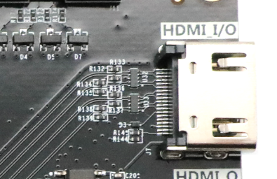 图片显示了HDMI输入接口的实物图，图中可以看到HDMI接口和周围的电路板布局。接口右侧标注有“HDMI I/O”，左侧有多个电阻和电容元件，以及一些标识为R132至R144的电阻。该图在文档中用于展示HDMI2输入接口的实物外观，帮助读者更好地理解电路设计和布局。