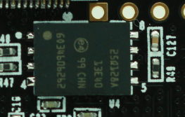 图片中展示了一块QSPI Flash芯片,其型号为69340S02562。芯片上标有“CHM”和“25Q128A”,表明其容量为128MB。芯片周围有多个引脚和焊接点,显示其已安装在电路板上。图片在文档中用于展示QSPI Flash在开发板上的实物图,帮助读者理解其在电路中的实际位置和连接方式。